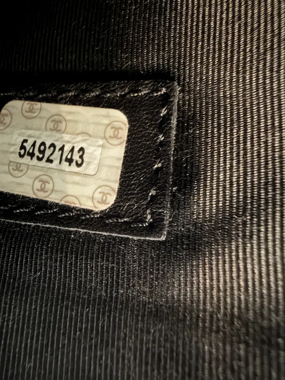 Close-up of a Chanel serial sticker inside a caviar leather tote