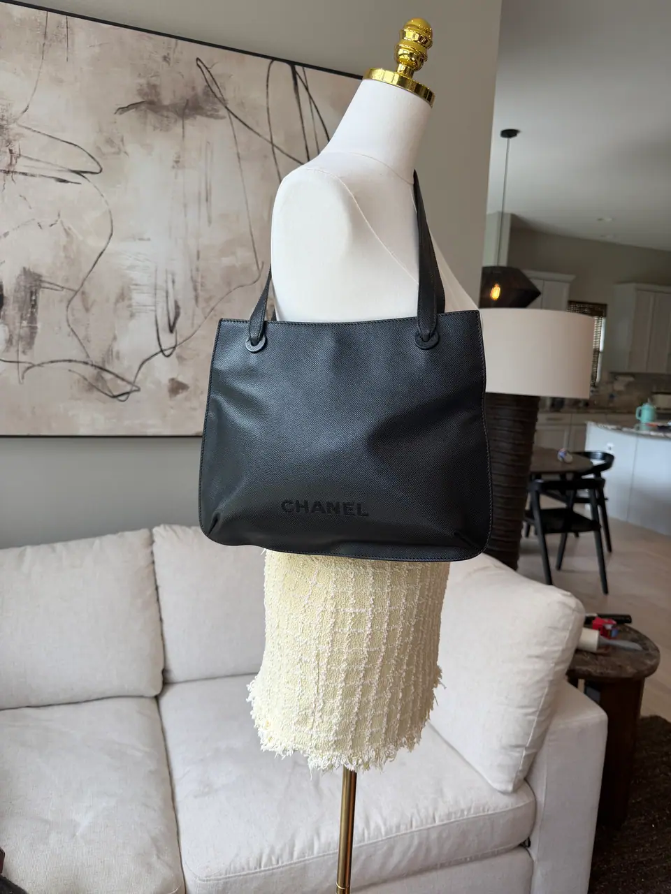 Two vintage black Chanel totes displayed on dress forms
